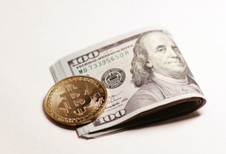 Coinbase - a stack of one hundred dollar bills and a bitcoin