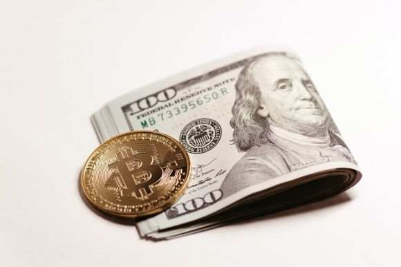 Coinbase - a stack of one hundred dollar bills and a bitcoin