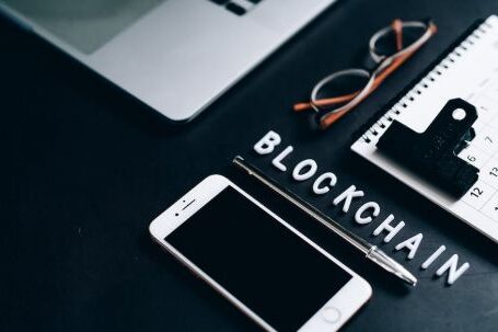 Blockchain - Smartphone, Pen, Calendar and Eyeglasses on Flat Surface