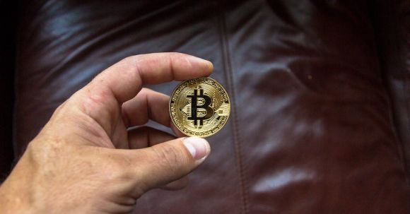 Blockchain - Round Gold-colored and Black Coin on Person's Hand